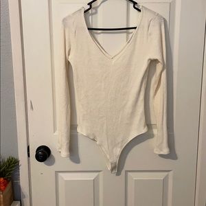 A cream long sleeve low v neck body suit